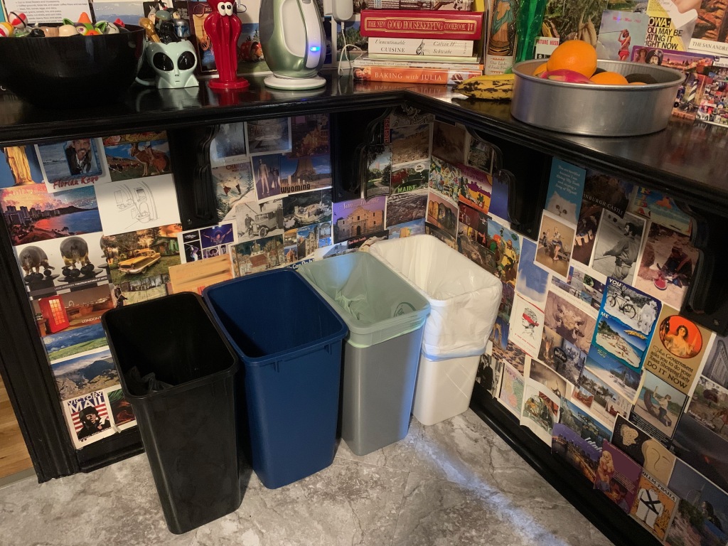 Bins for (from left to right) store drop-off plastic, recycling, compost, and trash.